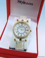   with a round gold tone case that features a shimmering crystal bezel